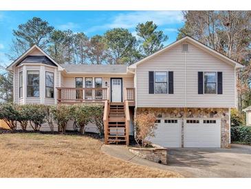 Charming home with a two-car garage, wood deck, stone accents, and mature landscaping at 1117 Mountain Springs Nw Dr, Kennesaw, GA 30144