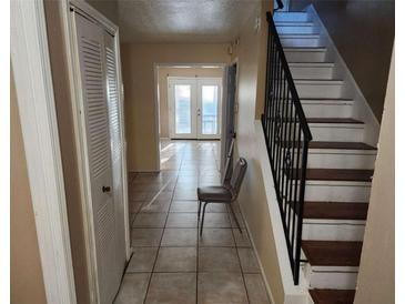 Inviting entryway features tiled floors, staircase and a bright window at the end of the hall at 2722 Penwood Pl, Lithonia, GA 30058