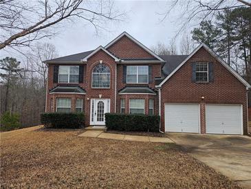 Charming brick two-story home featuring an attached two-car garage and manicured landscaping at 4667 Derby Loop, Fairburn, GA 30213