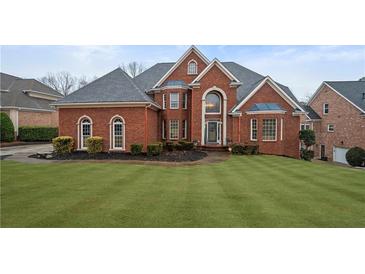 Stunning brick home with lush lawn, mature landscaping, and a stately, symmetrical facade at 3428 Stembler Rdg, Douglasville, GA 30135