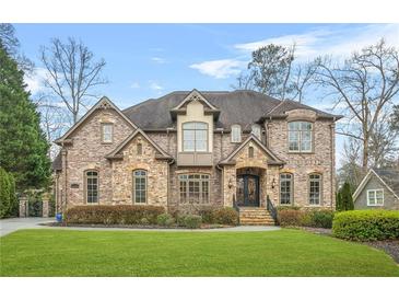 Stunning brick home featuring meticulous landscaping, arched windows, and an elegant entry staircase at 2373 Greenglade Ne Rd, Atlanta, GA 30345