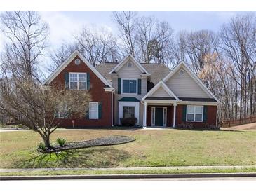 Charming two-story home with brick and siding, green shutters and a well-manicured lawn at 3641 Willow Club Dr, Loganville, GA 30052