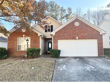 Charming one-story home featuring a brick facade, attached two-car garage, and manicured lawn at 396 Avian Forest Dr, Stockbridge, GA 30281