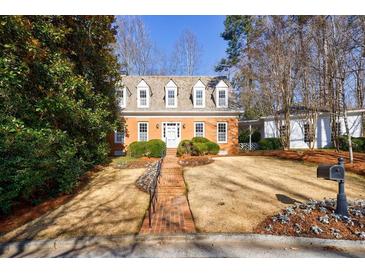 Charming brick home with symmetrical design, dormer windows, and a meticulously landscaped front yard at 2650 Peachtree Battle Nw Pl, Atlanta, GA 30327