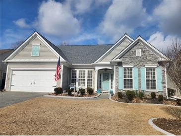 Charming single-story home with stone accents, blue shutters, manicured landscaping, and an American flag at 912 Santa Anita Dr, Woodstock, GA 30189