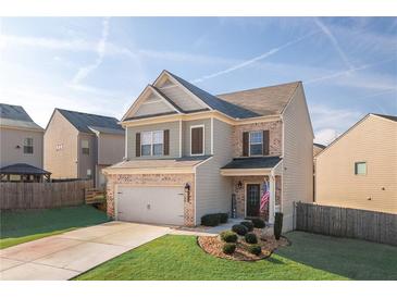 Charming two-story home with a brick-accented facade, two-car garage and well-manicured lawn at 2066 Charcoal Ives Rd, Lawrenceville, GA 30045