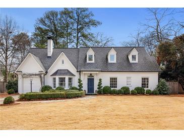 Charming two-story white brick home with manicured front yard and mature trees at 3063 Peachtree Ne Dr, Atlanta, GA 30305