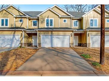 New townhome featuring a two-car garage, neutral paint, and stone accents at 6880 Robinson St, Lithonia, GA 30058