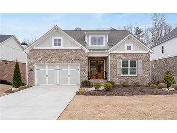 Charming brick home with a well-manicured lawn, two-car garage, and inviting front porch at 3750 Montebello Pkwy, Cumming, GA 30028