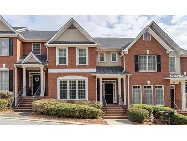 Beautiful red brick townhome with black shutters and a well-maintained front yard at 4779 Longcourt Dr # 21, Atlanta, GA 30339