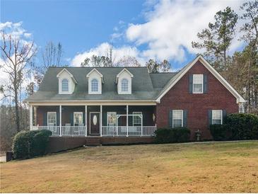 Charming brick home with a welcoming front porch and well-manicured landscaping at 1000 Eddie Craig Dr, Mcdonough, GA 30252