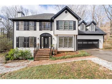 Charming two-story home with black and white accents, a well-manicured lawn and an attached two car garage at 2321 Birdie Ln, Duluth, GA 30096