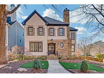 Charming two-story home boasts a stone chimney, landscaped yard, and inviting front entrance at 1527 Markan Ne Dr, Atlanta, GA 30306