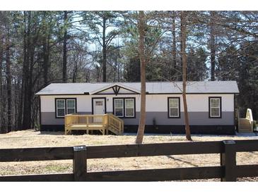 Charming single-story home with a welcoming front porch nestled among tall trees at 7382 Knox Bridge Hwy, Canton, GA 30114