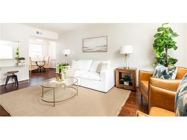 Cozy living room featuring a white sofa, brown leather chairs and a glass coffee table at 100 Biscayne Nw Dr # 4, Atlanta, GA 30309