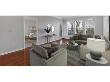 Sunlit living room boasts hardwood floors, neutral tones, and contemporary furnishings at 1850 Cotillion Dr # 4204, Dunwoody, GA 30338