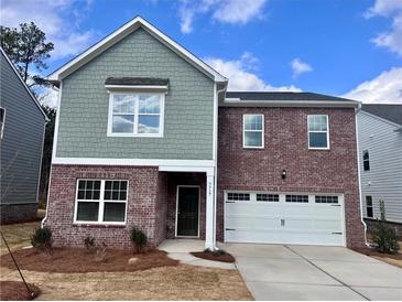 Charming two-story home featuring a brick facade and a two-car garage at 7717 Sudbury Cir, Covington, GA 30014