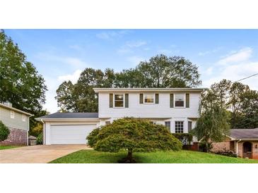 Inviting two-story home with white siding, green shutters and lush front yard at 3119 Windfield Cir, Tucker, GA 30084