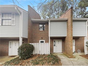 Charming two-story townhouse with brick accents, white siding, and inviting entrance at 6090 Wintergreen Rd # 1A3, Norcross, GA 30093