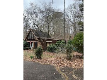 Charming home featuring unique architectural details and surrounded by mature trees at 5435 Hearn Rd, Ellenwood, GA 30294