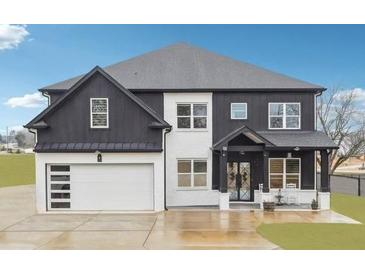 Two-story modern farmhouse with black siding, white brick, and a spacious three-car garage at 557 Loth Wages Rd, Dacula, GA 30019