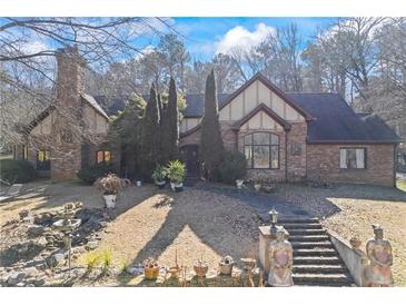 Charming stone and brick home with manicured front yard, mature trees, and a fountain at 3000 Cathedral Pl, Decatur, GA 30034