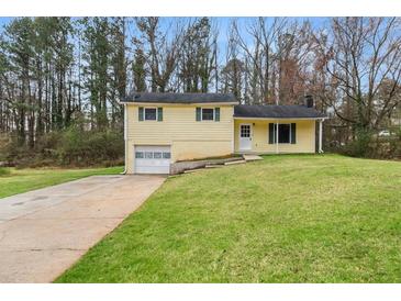 Charming yellow home features an attached garage and a well-manicured lawn at 72 Diane Ct, Dallas, GA 30157