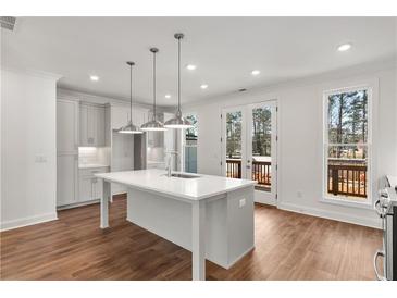 Bright kitchen features a large center island, pendant lighting, and stainless steel appliances, seamlessly connecting to the outdoors at 2360 Elgar Park Pl # 99, Duluth, GA 30096