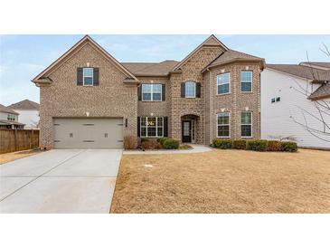 Two-story brick home features an attached garage, manicured bushes, and a well-maintained lawn at 380 Parkside Meadow Sw Dr, Marietta, GA 30064