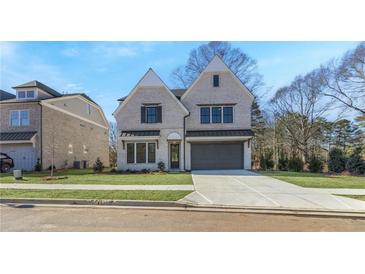 Beautiful two-story brick home with manicured lawn and attached two-car garage at 3909 Enclave Way, Tucker, GA 30084