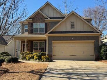 Charming two-story home featuring a stone facade, covered porch, and a spacious two-car garage at 5211 Centennial Hill Nw Dr, Acworth, GA 30102