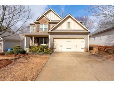 Charming two-story home with a stone facade, a well-manicured lawn and a two-car garage at 5211 Centennial Hill Nw Dr, Acworth, GA 30102