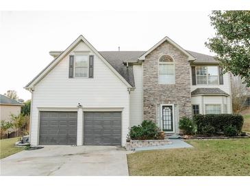 Charming two-story home with stone accents, a well-manicured lawn, and a two-car garage at 625 Rockbass Rd, Suwanee, GA 30024