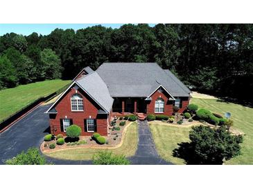 Beautiful brick home with manicured landscaping, mature trees, and an asphalt driveway at 5780 Warren Farm Sw Rd, Powder Springs, GA 30127