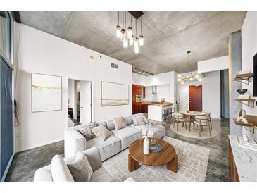 Open living room featuring a modern sofa, round wood table, and decorative lighting fixtures at 130 Arizona Ne Ave # 106, Atlanta, GA 30307