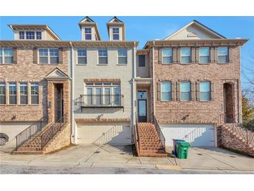 Exterior view of brick townhomes with driveways and front entry stairs at 1912 Townsend Ne Ct, Atlanta, GA 30329