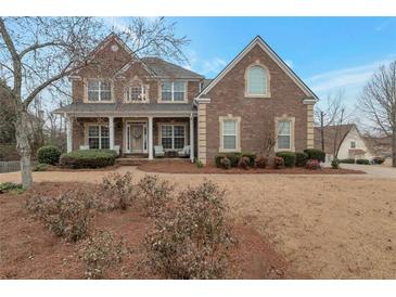 Charming two-story brick home with inviting front porch and manicured landscaping at 726 Fraser Ct, Mcdonough, GA 30253