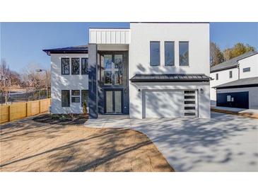 Striking two-story modern home with a white brick facade, black accents, and an attached two-car garage at 734 Riverside Rd, Sugar Hill, GA 30518