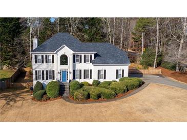 Charming two-story white home with black shutters, blue door, landscaped yard, and a private driveway at 4550 Wenden Ln, Marietta, GA 30062