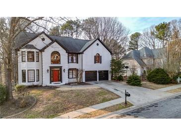 Stunning two-story white brick home with a well-manicured lawn and a two-car garage at 559 Fairway Dr, Woodstock, GA 30189