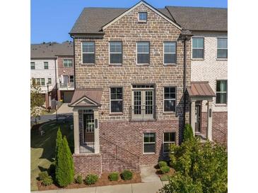 Charming brick townhome featuring a covered entry, and wrought iron railings at 414 Montclair Ct, Woodstock, GA 30188