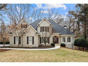 Charming brick home with a manicured lawn and well-maintained landscaping at 10635 N Edgewater Pl, Johns Creek, GA 30097