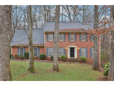 Charming brick home featuring a classic design with blue shutters and a well-manicured front yard at 3417 Starwood Sw Trl, Lilburn, GA 30047