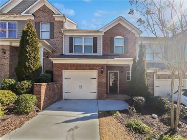Charming brick townhome with a one-car garage and manicured landscaping at 3194 Haynes Park Dr, Lithonia, GA 30038