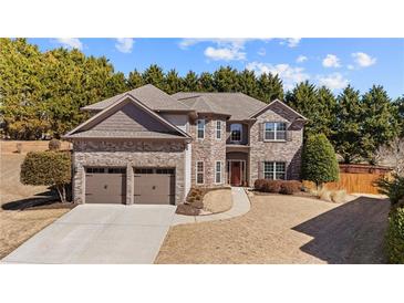 Charming two-story home with a brick and stone facade, complemented by a well-manicured lawn and a two-car garage at 3830 Deer Run Dr, Cumming, GA 30028