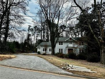 Charming two-story home with classic architectural details and a welcoming front porch, nestled among mature trees at 4402 Blackland Dr, Marietta, GA 30067