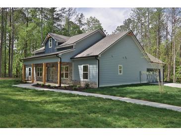 Charming home with a welcoming front porch featuring stone accents and sturdy wooden support columns at 2117 Hwy 101 N, Dallas, GA 30157