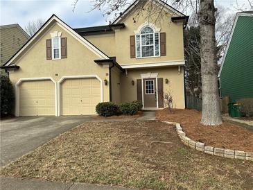 Charming home featuring a two-car garage, manicured landscaping, and a welcoming entrance at 430 Citronelle Dr, Woodstock, GA 30188