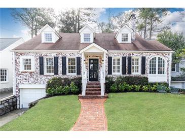 Charming brick home with dormers, black shutters, brick walkway, and well-manicured lawn and landscaping at 2911 N Hills Ne Dr, Atlanta, GA 30305