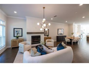 Open-concept living room featuring a cozy fireplace, modern lighting, and stylish furniture at 604 Goldsmith Ct # 115, Johns Creek, GA 30022